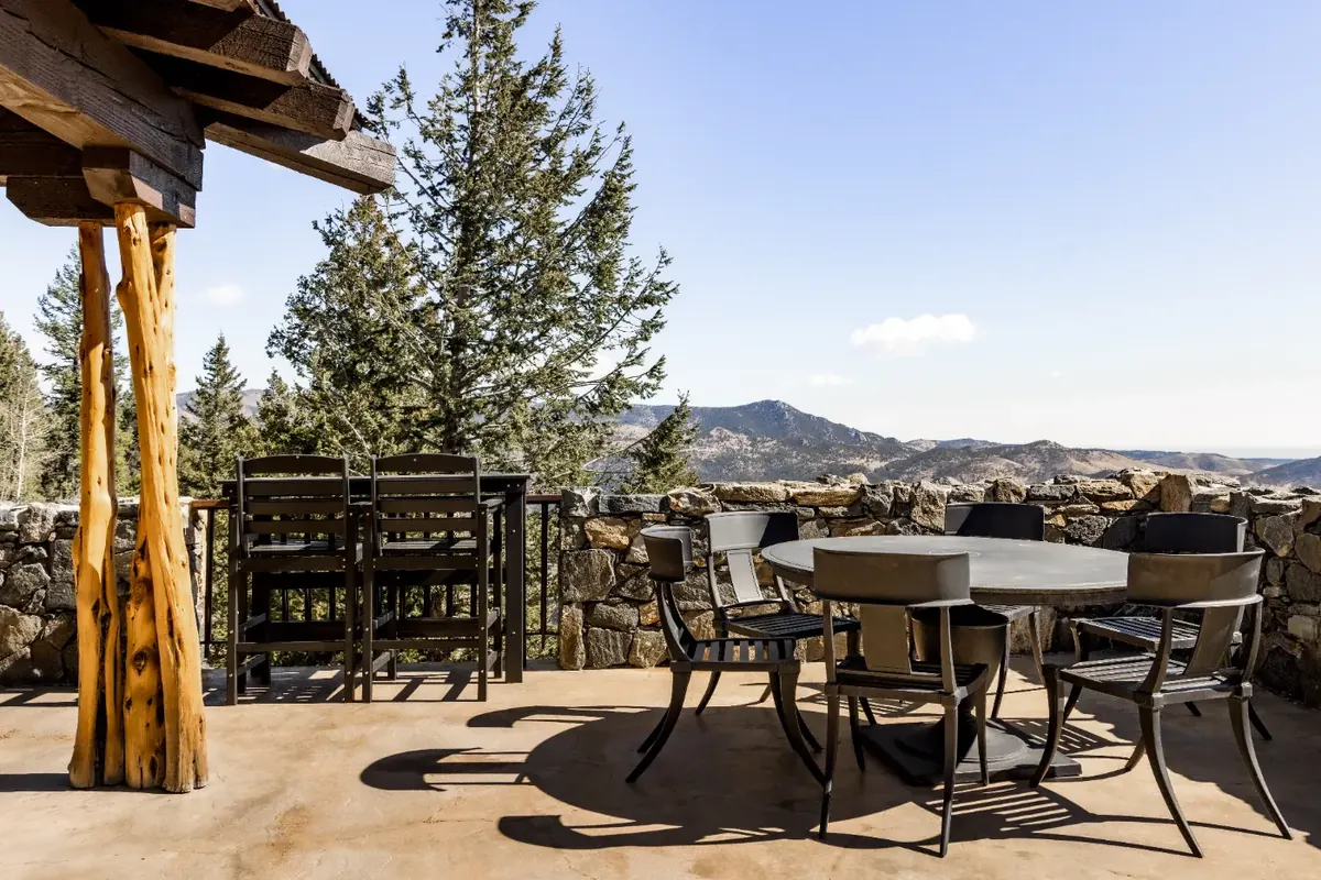 Covered timber deck with dining table and mountain view at a Colorado rental