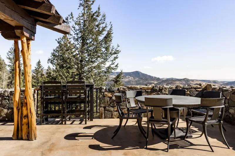 Covered timber deck with dining table and mountain view at a Colorado rental