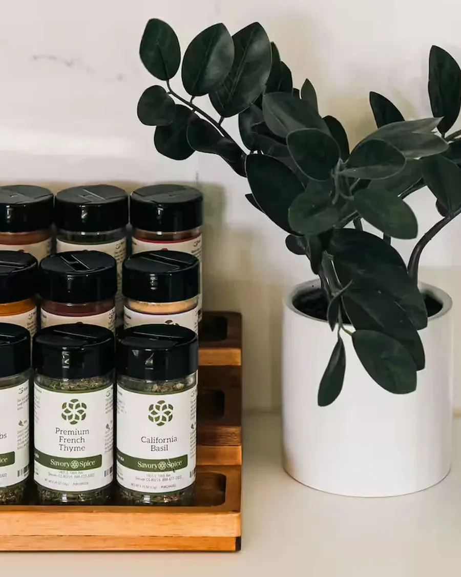 Restocked kitchen shelf with labeled spice jars and olive oil in a Colorado short term rental